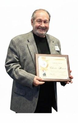 Charles Henault holding an award plaque